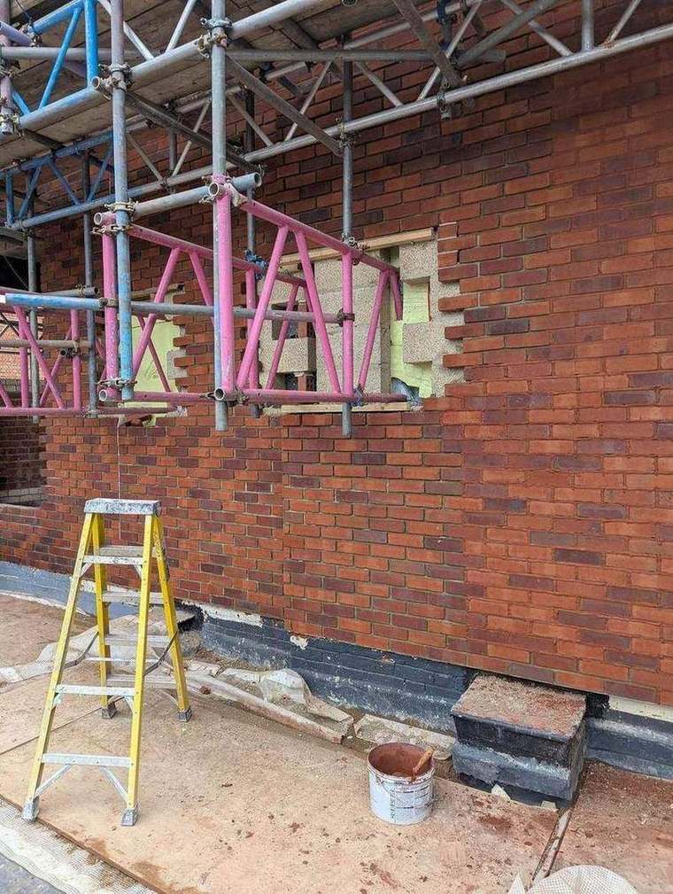 Brickwork rising behind scaffold at Albion Street
