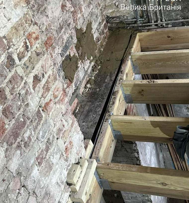 Timber needle beams supporting the party wall during underpinning