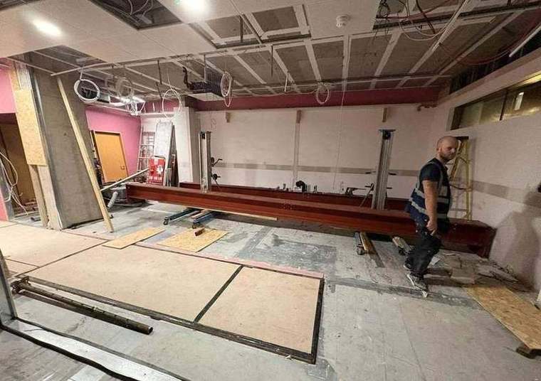 Long steel beam moved through the building on skates