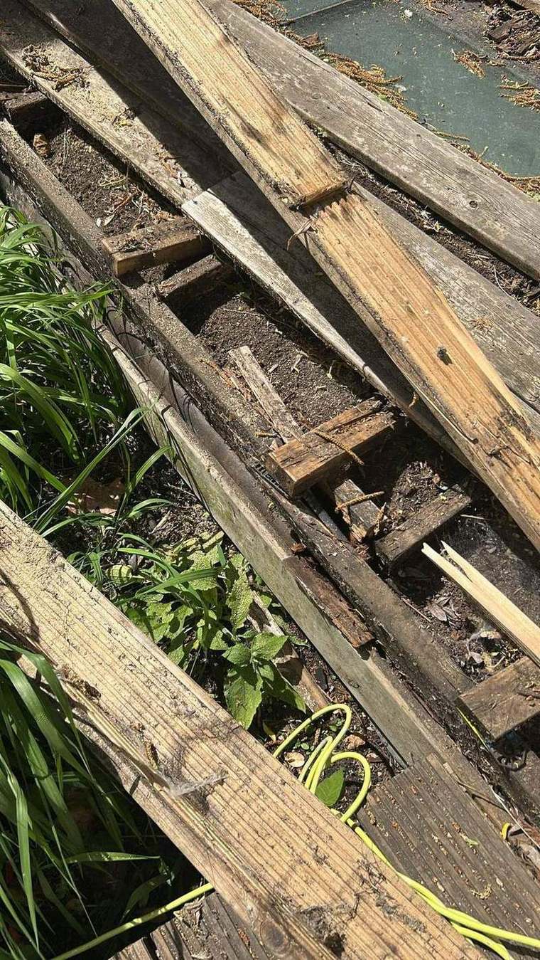 Rotten decking sub-frame exposed after the boards were lifted